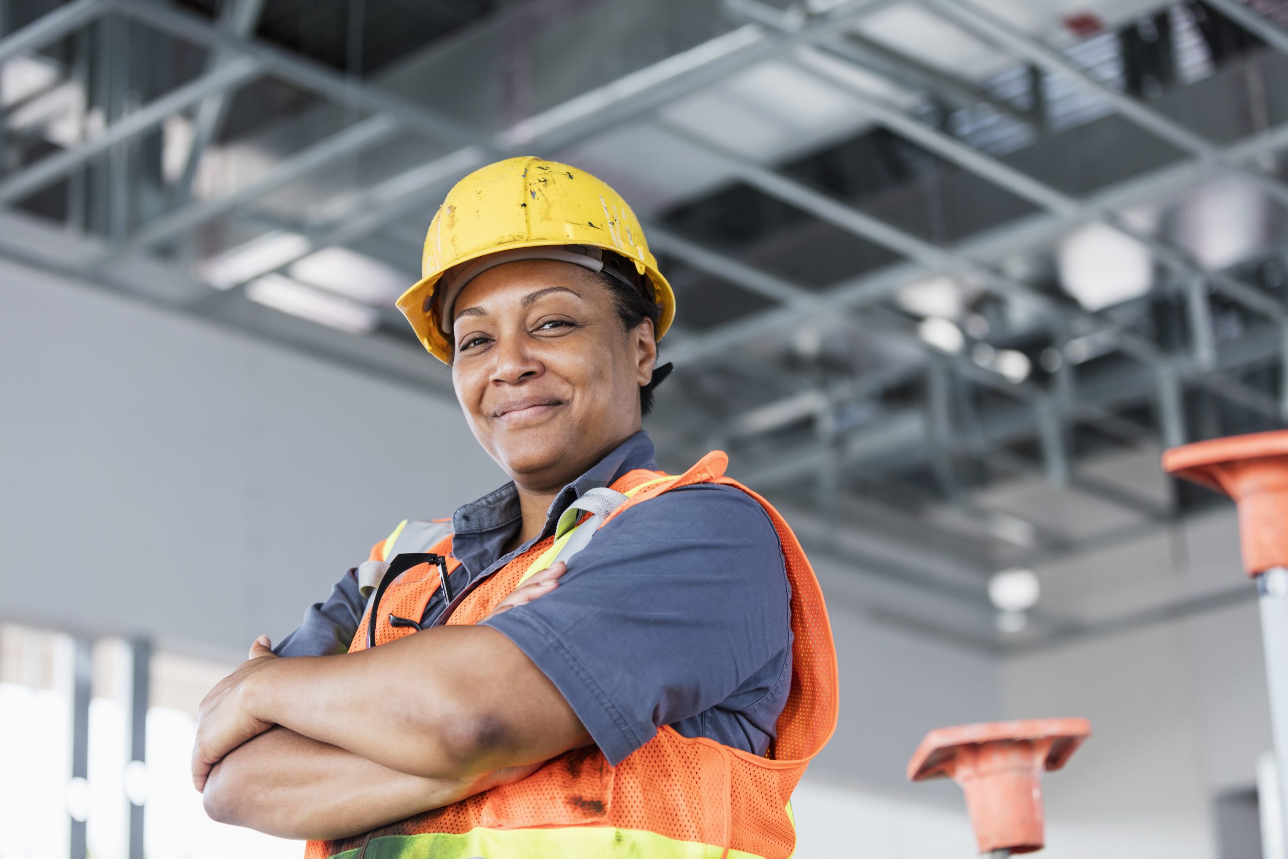 Woman construction worker standing with arms crossed